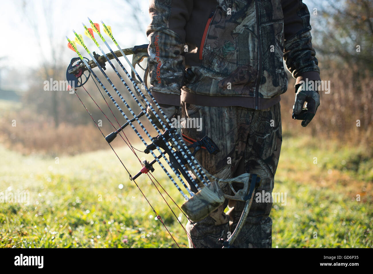 Giovani maschi adulti hunter camminare nel campo Cerca per cervi durante la stagione di prua Foto Stock