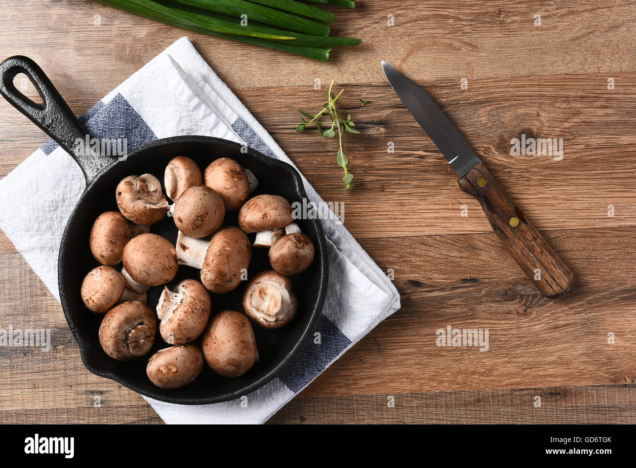 Vista dall'alto di una padella in ghisa riempito con funghi freschi in procinto di essere saltata. Foto Stock