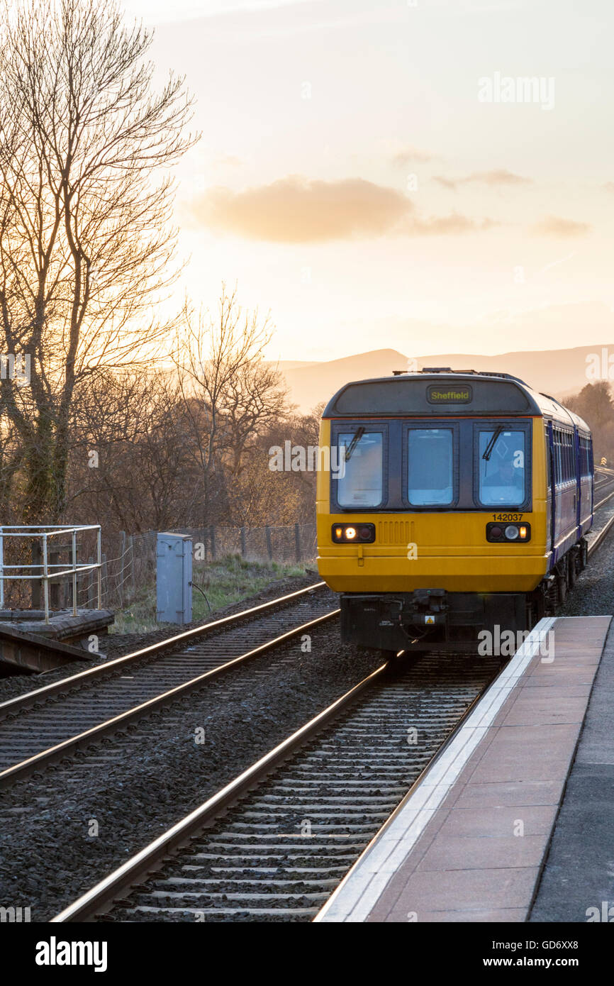 Treno locale sulla speranza della linea a valle al crepuscolo in avvicinamento al rurale stazione ferroviaria a Hathersage, Derbyshire, Peak District, England, Regno Unito Foto Stock