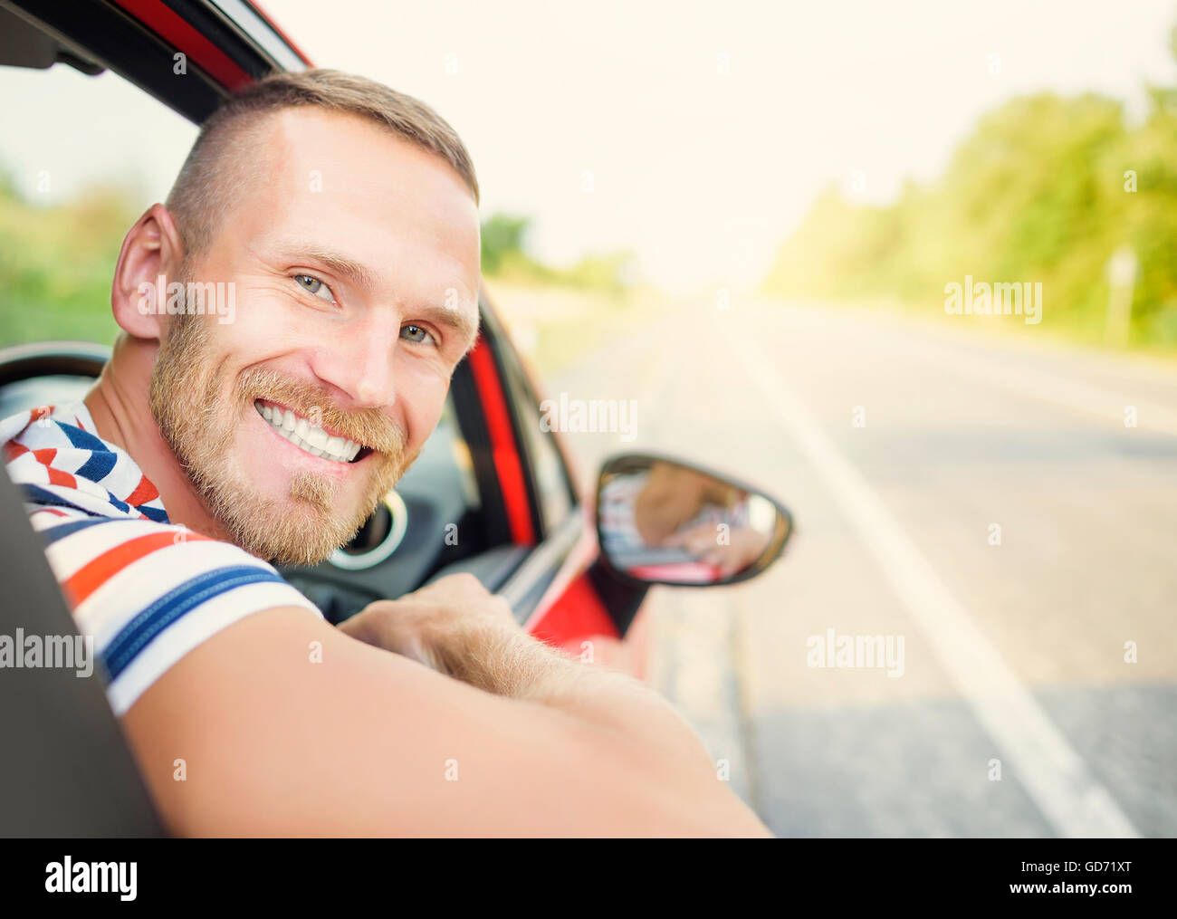 Driver. Vista posteriore. Attraente giovane nel nuovo automobile rossa sulla strada. Foto Stock