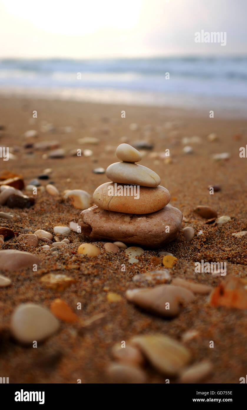 Pyramid realizzata con ciottoli bagnata pietre sul mare spiaggia, Korfu Island, Grecia Foto Stock
