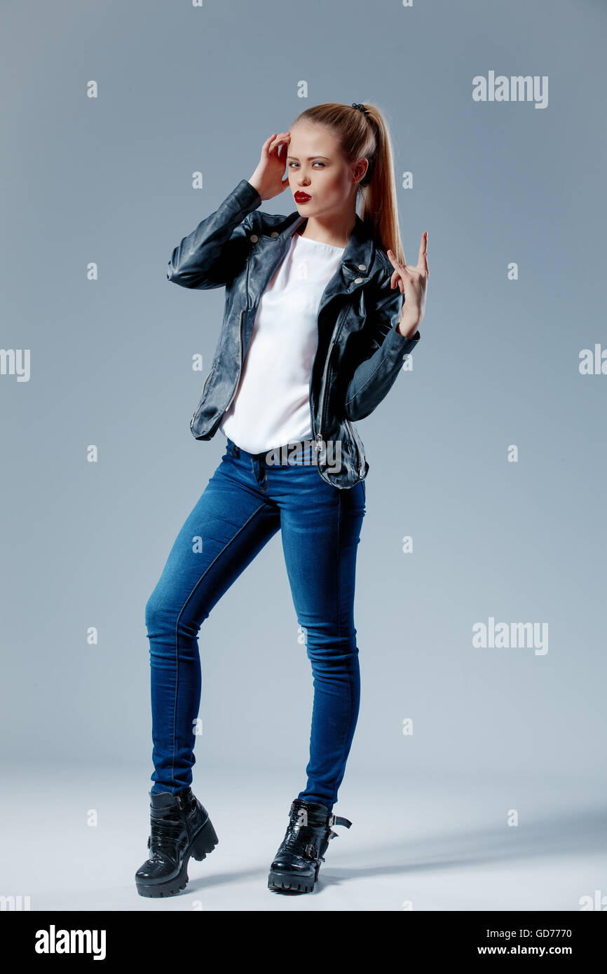 Modello di moda tirando i suoi capelli in coda e guardando la fotocamera Foto Stock