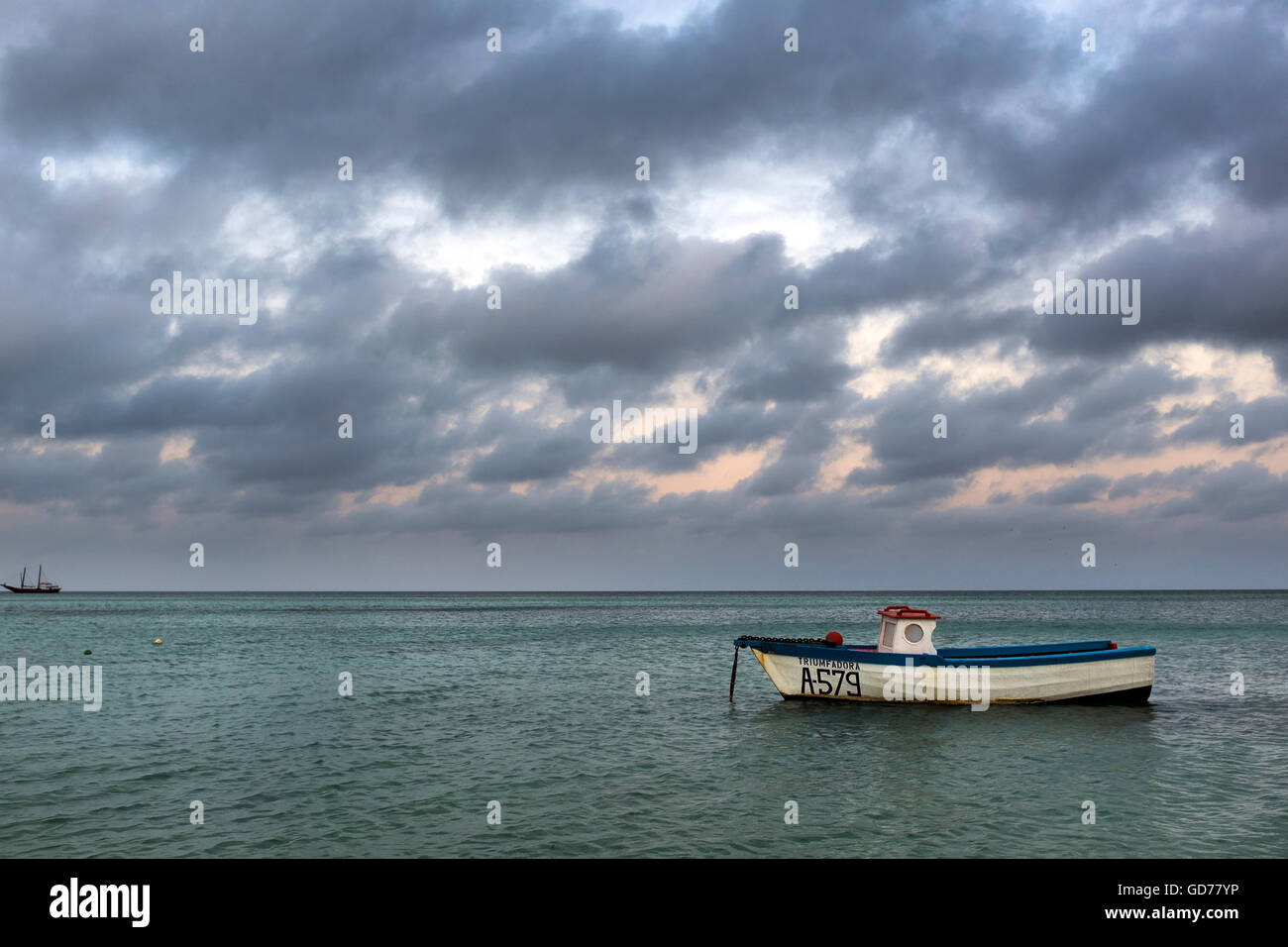 Nuvoloso al mattino e barca da pesca, Palm Beach, Aruba. Foto Stock