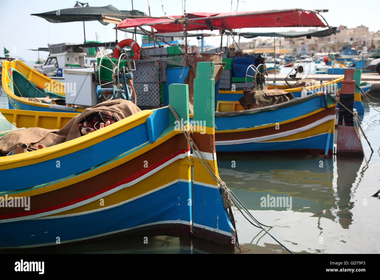 Il vecchio tradizionale maltese Luzzu barche legato fino al molo Foto Stock