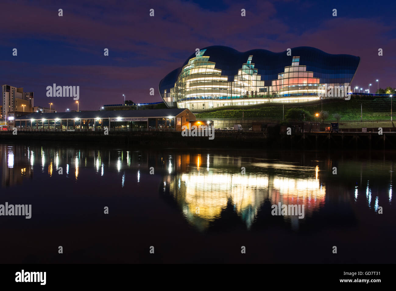 Il Sage Music Venue è illuminata di notte in Gateshead, e riflessa nel fiume Tyne. Foto Stock