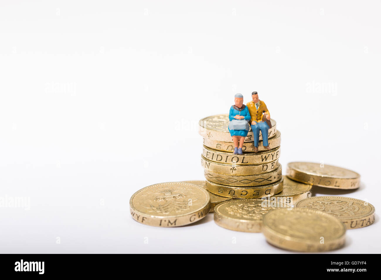 Concetto di immagine di due pensionati seduto su una pila di libbra di monete Foto Stock