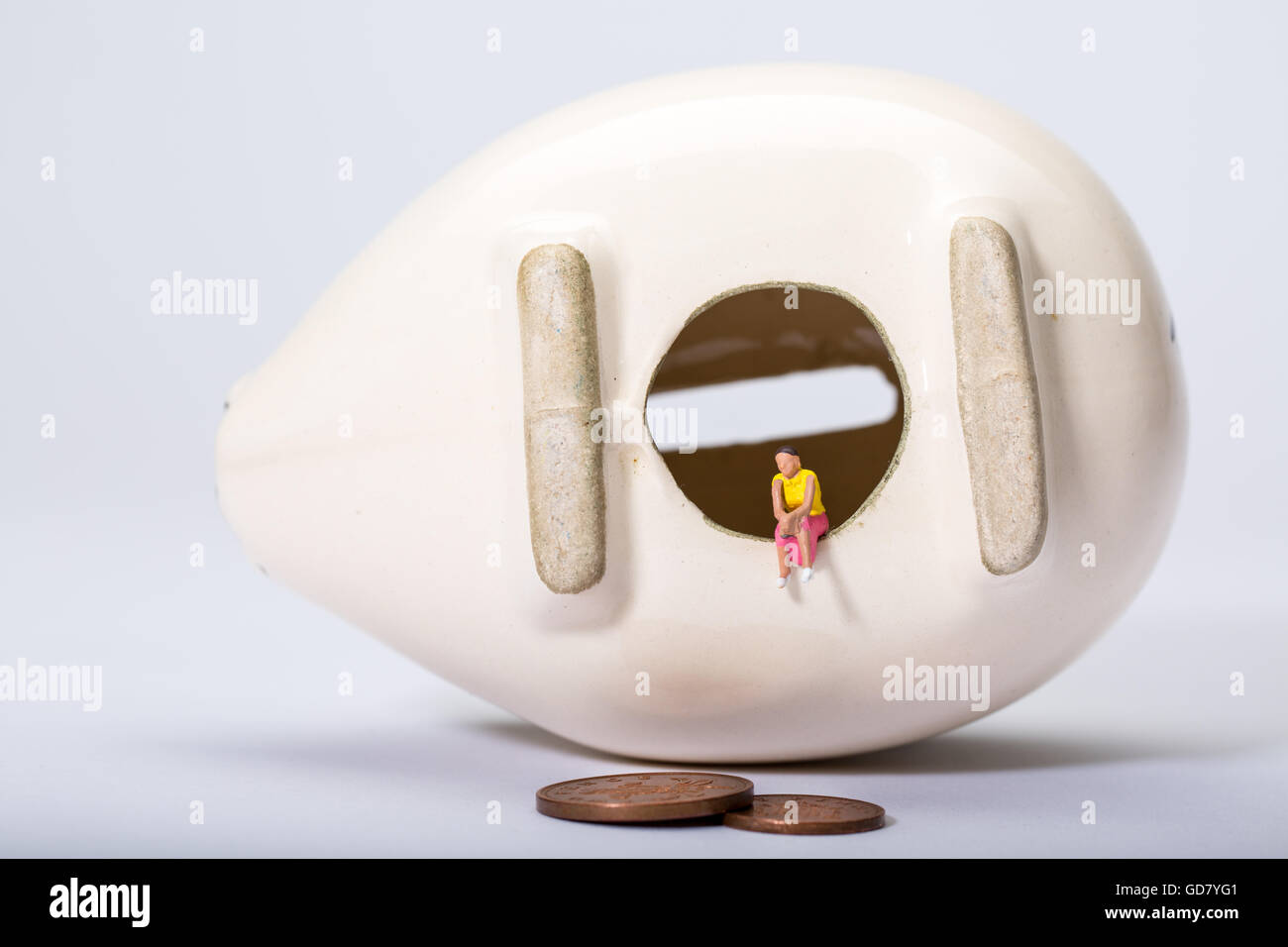 Concetto di immagine di una solitaria figura con un vuoto di salvadanaio per illustrare a bassa di risparmio e di bassi tassi di interesse sul risparmio Foto Stock