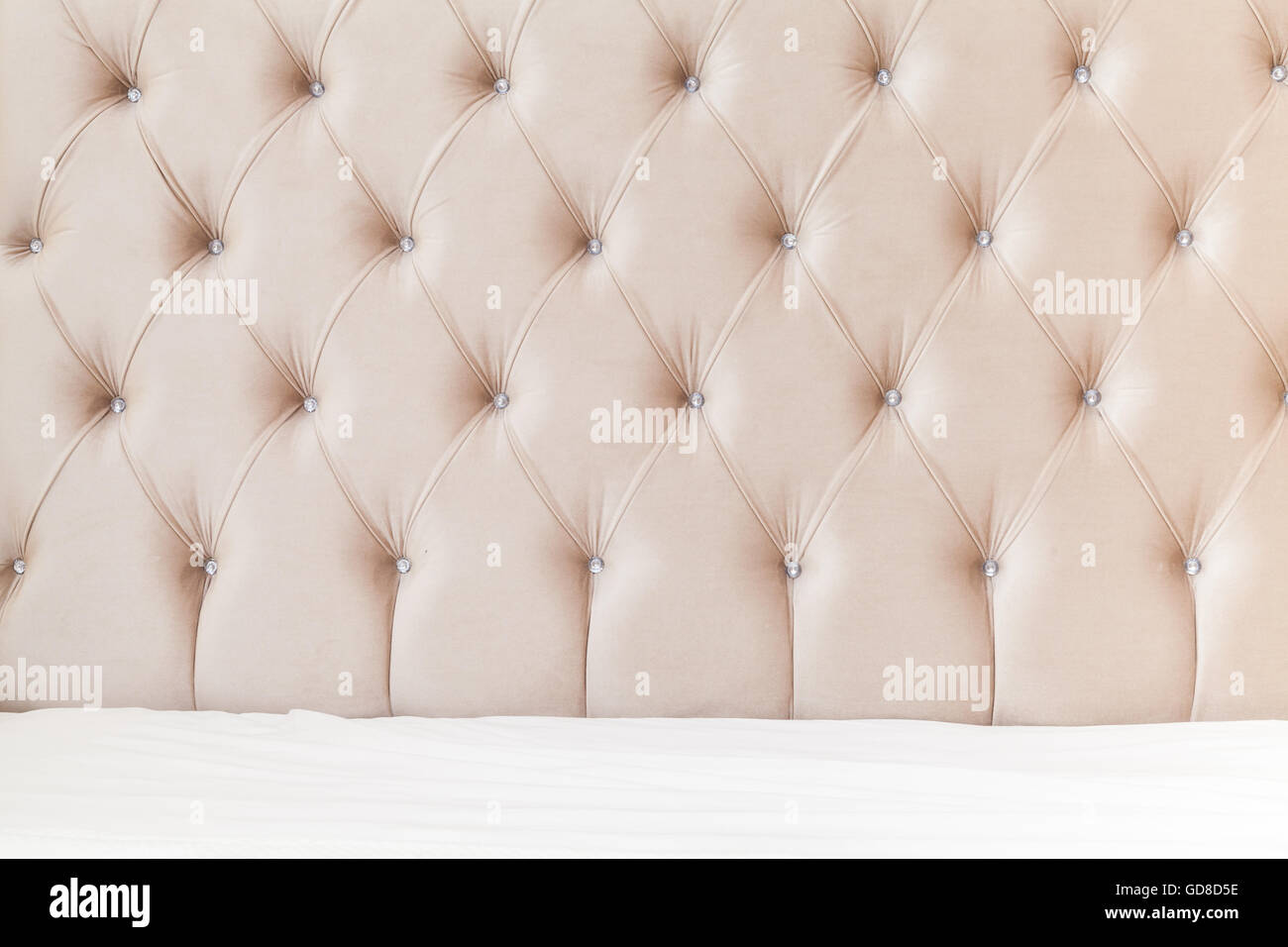 Lussuosa camera da letto vuoto interiore, sfondo rosa soffice testiera del letto e biancheria da letto bianca fogli su ampio letto matrimoniale Foto Stock