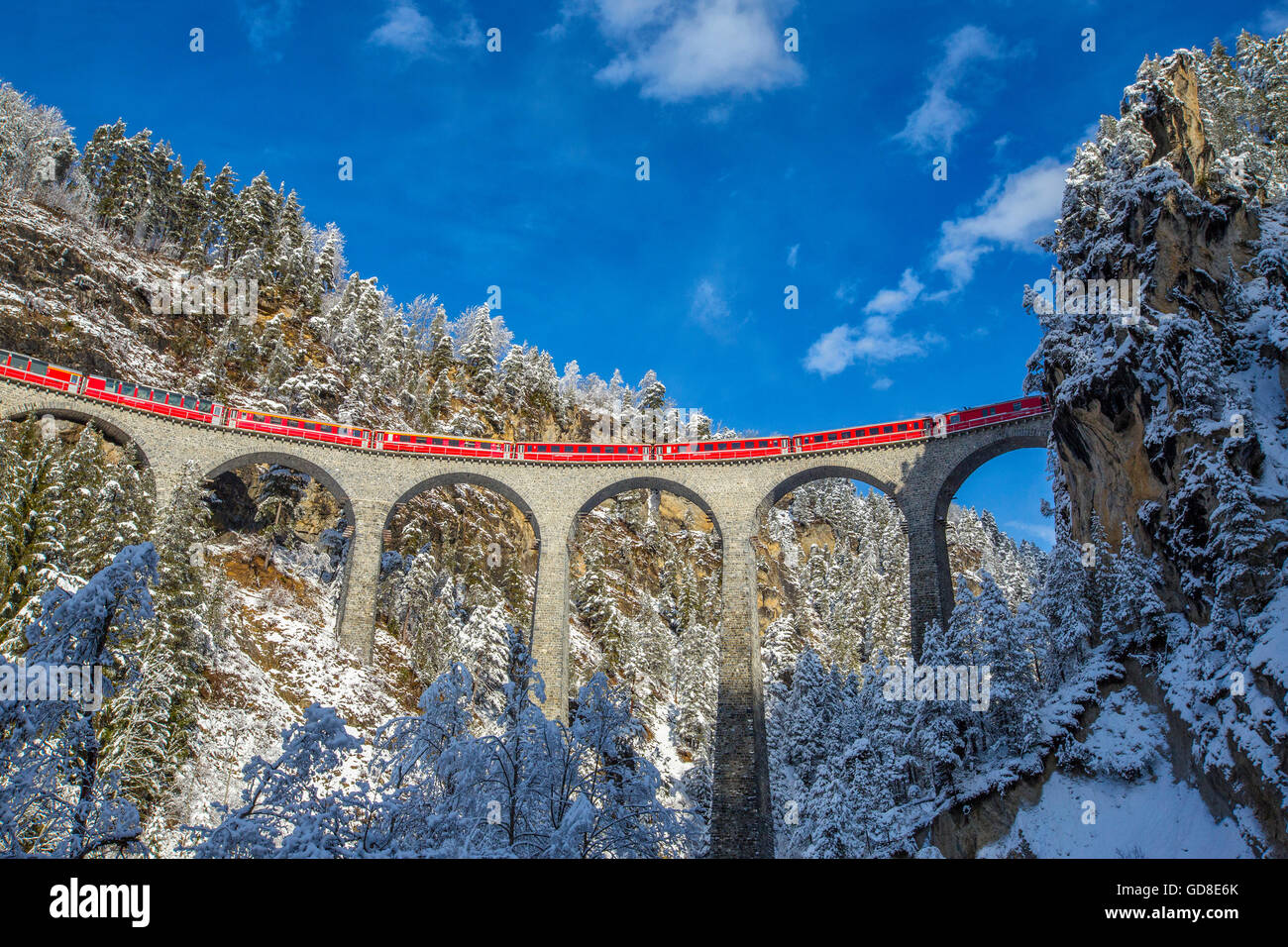 Bernina Express passa attraverso i boschi innevati intorno a Filisur Cantone dei Grigioni Svizzera Europa Foto Stock