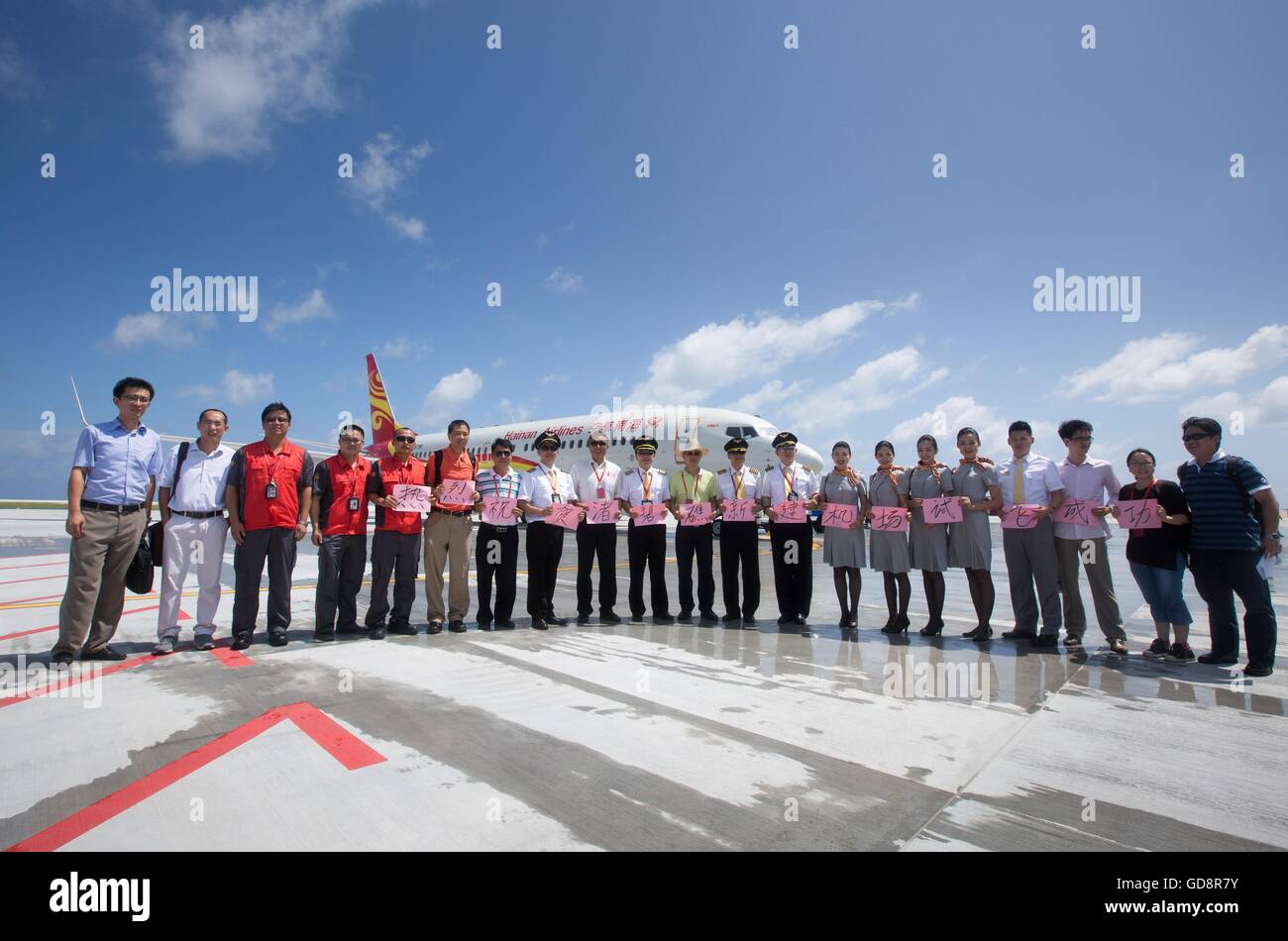 Haikou, Cina. 13 Luglio, 2016. Persone posano per una foto di gruppo dopo un getto di passeggero di Hainan Airlines in atterraggio all'aeroporto su Zhubi Reef, 13 luglio 2016. Cina effettuate con successo i voli di collaudo su due nuovi aeroporti delle isole Nansha nel Mare della Cina del Sud Mercoledì, aumentando ulteriormente la sua capacità di fornire servizi pubblici come un protagonista responsabile nella regione. Credito: Xinhua/Alamy Live News Foto Stock