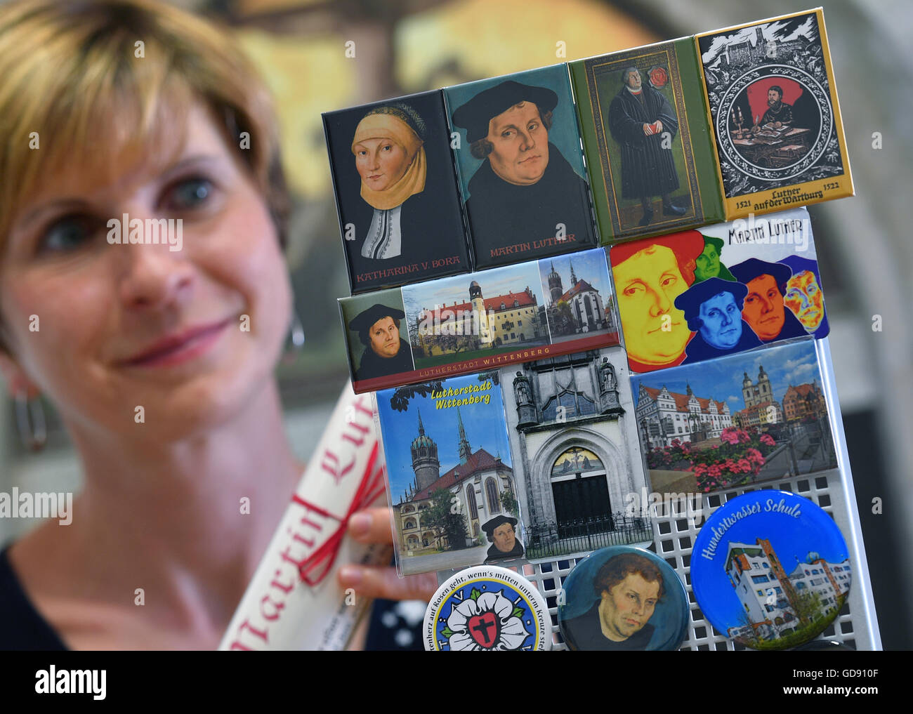 Wittenberg, Germania. 05 Luglio, 2016. Diana Schellhaas esamina diversi magneti recanti immagini di Martin Lutero e di sua moglie Katharina von Bora, in informazioni turistiche di Wittenberg, Germania, 05 luglio 2016. Con un anno di anticipo del anniversario della Riforma Protestante, souvenir dalla città dimostrano di essere molto popolare tra i turisti. Merce offerta in vendita includono Luther-tema calzini e Playmobil figure. Foto: HENDRIK SCHMIDT/dpa/Alamy Live News Foto Stock