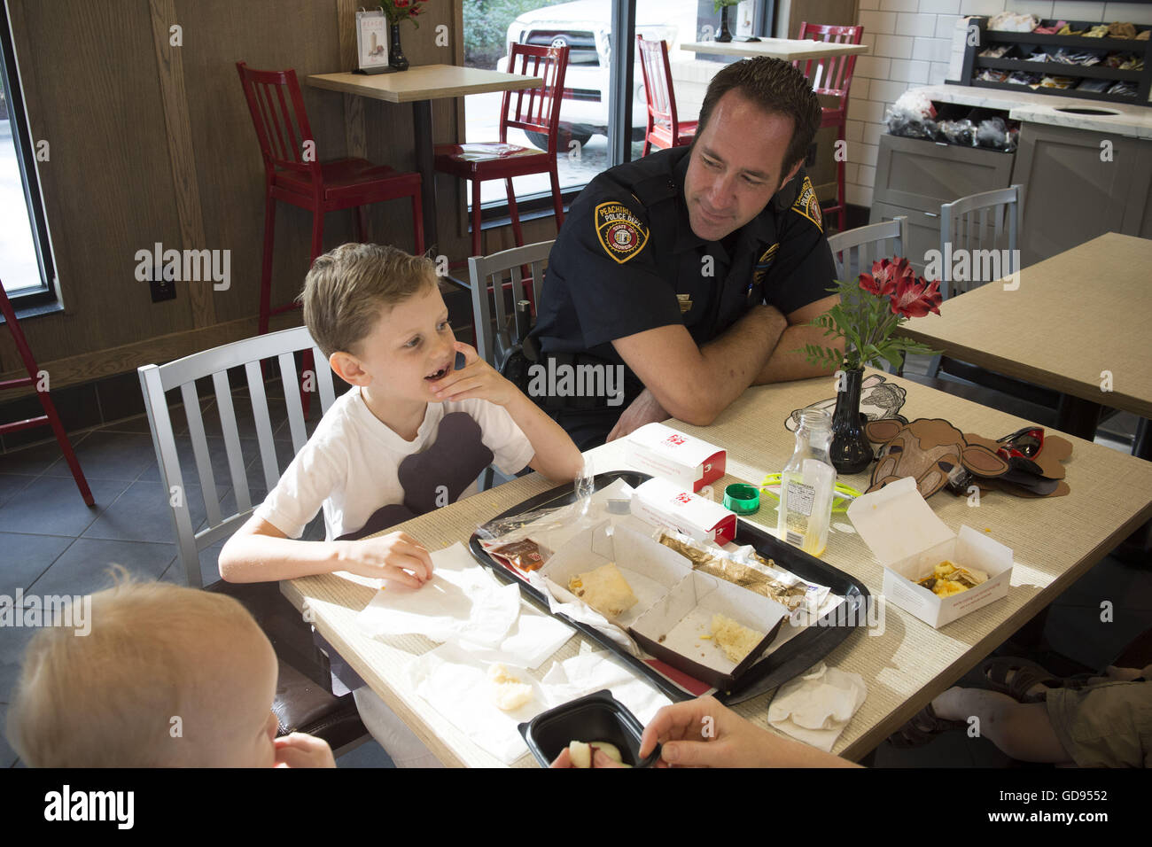 Peachtree City, GA, Stati Uniti d'America. 12 Luglio, 2016. Ufficiale di polizia chat con i giovani clienti presso un ''caffè con un COP'' mattina al Pulcino-fil-Un ristorante sulla mucca apprezzamento al giorno. © Robin Rayne Nelson/ZUMA filo/Alamy Live News Foto Stock