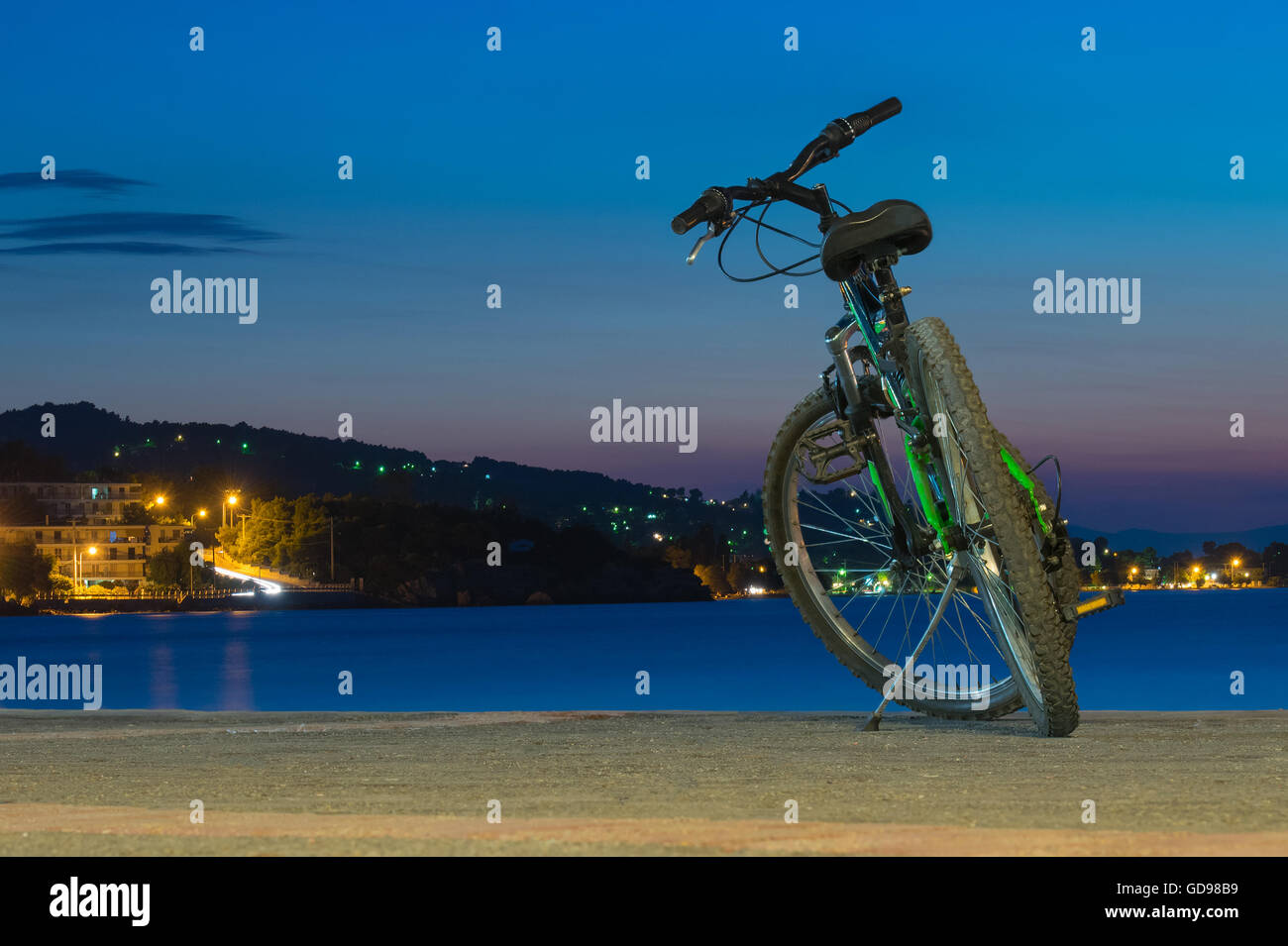 Bicicletta di montagna contro il mare e il bel tramonto al villaggio di Kalamos in Grecia. Foto Stock