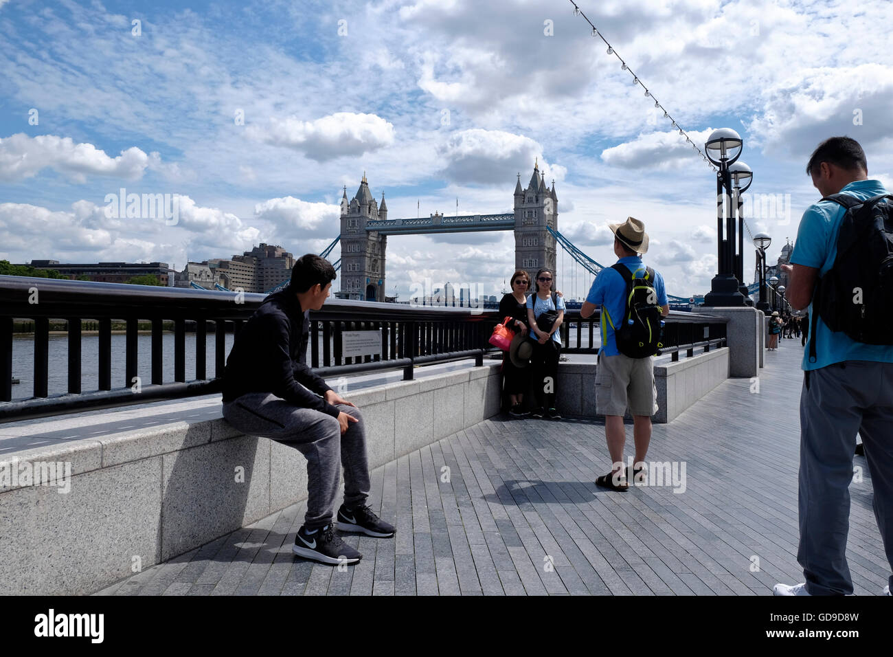 Londra, Regno Unito. I turisti pongono per le fotografie su Queens a piedi con il Tower Bridge e la skyline di Londra in background Foto Stock