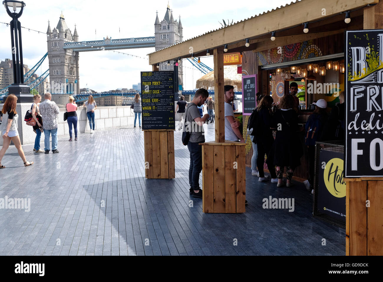 Un cibo in stallo sulla passerella sulla riva sud del Tamigi London Bridge è in background. Foto Stock