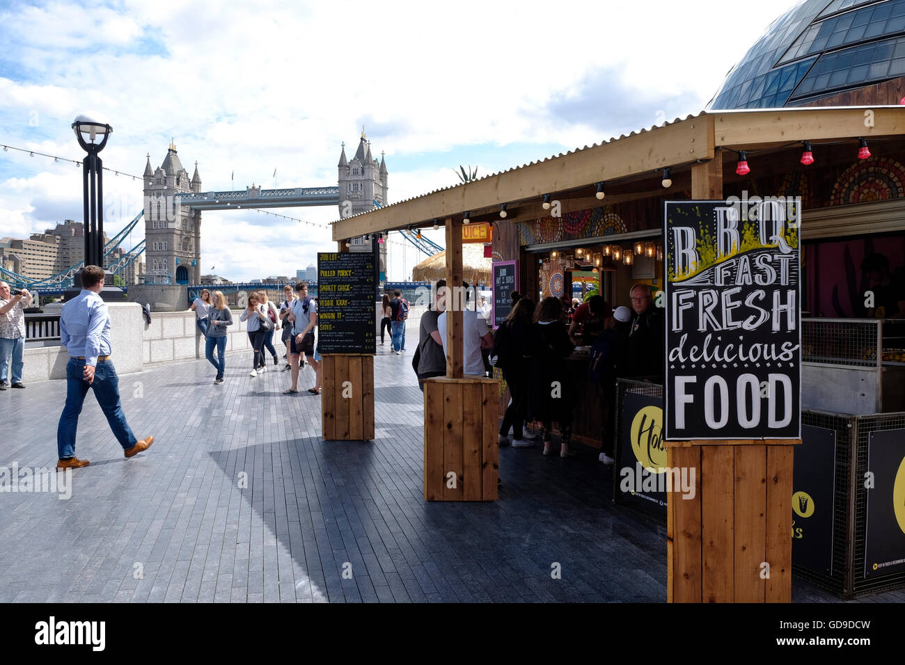 Un cibo in stallo sulla passerella sulla riva sud del Tamigi London Bridge è in background. Foto Stock
