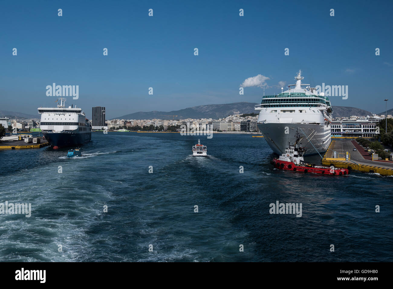 Una nave da crociera (a destra) e un traghetto (sinistra) presso il porto greco del Pireo. Il porto del Pireo è il più grande porto greco, è uno dei più grandi porti marittimi in Europa e nel mondo, che si trova nel Mar Mediterraneo bacino. Il porto di Pireo è servito come il porto di Atene sin dai tempi antichi. Foto Stock