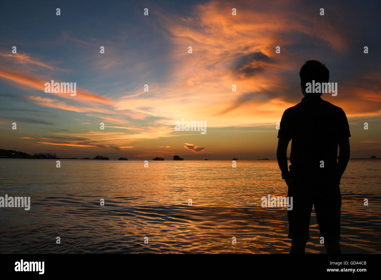 Silhouette di uomo al tramonto sulla spiaggia di Pattaya, Thailandia Foto Stock