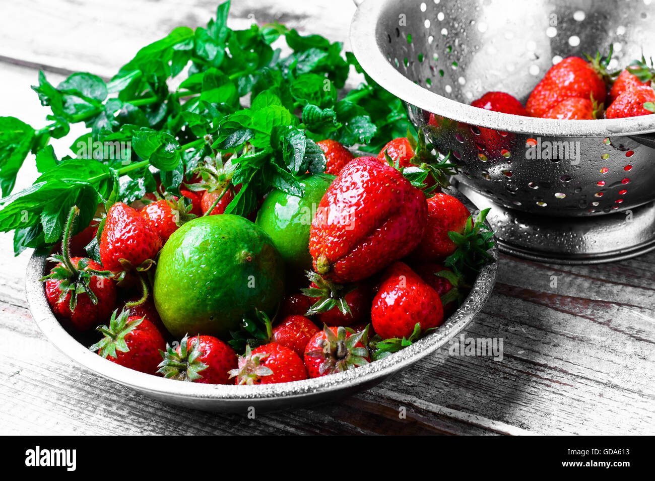 Piatto con maturi fragole grandi,lime e foglie di menta piperita Foto Stock