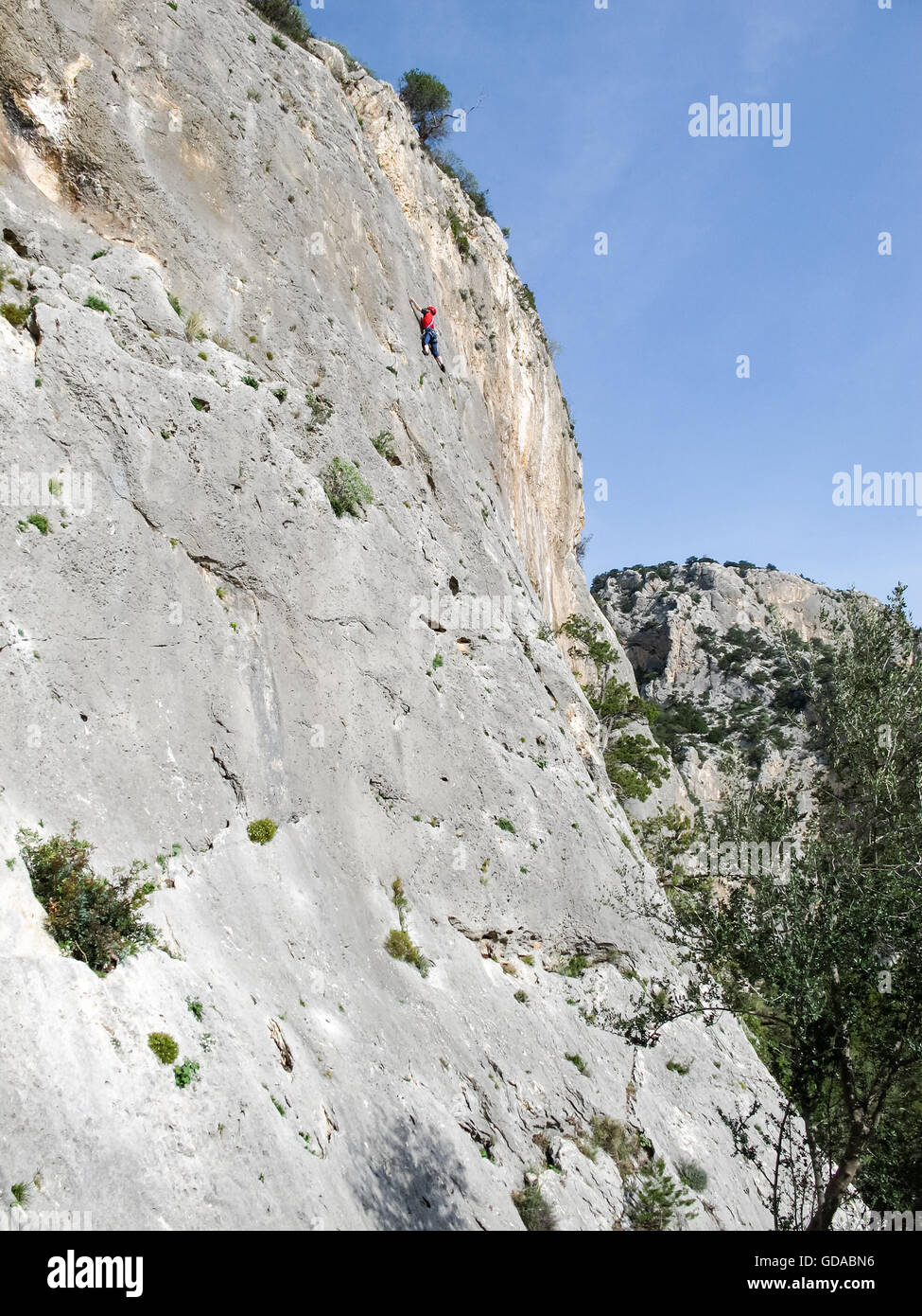 L'Italia, Sardegna, arrampicata sulla scogliera ripida parete di roccia con scalatore Foto Stock