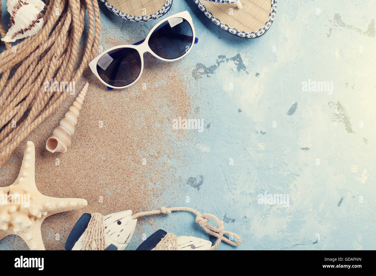 Accessori da spiaggia. Occhiali da sole, flip-flop e conchiglie di mare su  sfondo di pietra. Vista da sopra con copia spazio. Sunny tonica Foto stock  - Alamy
