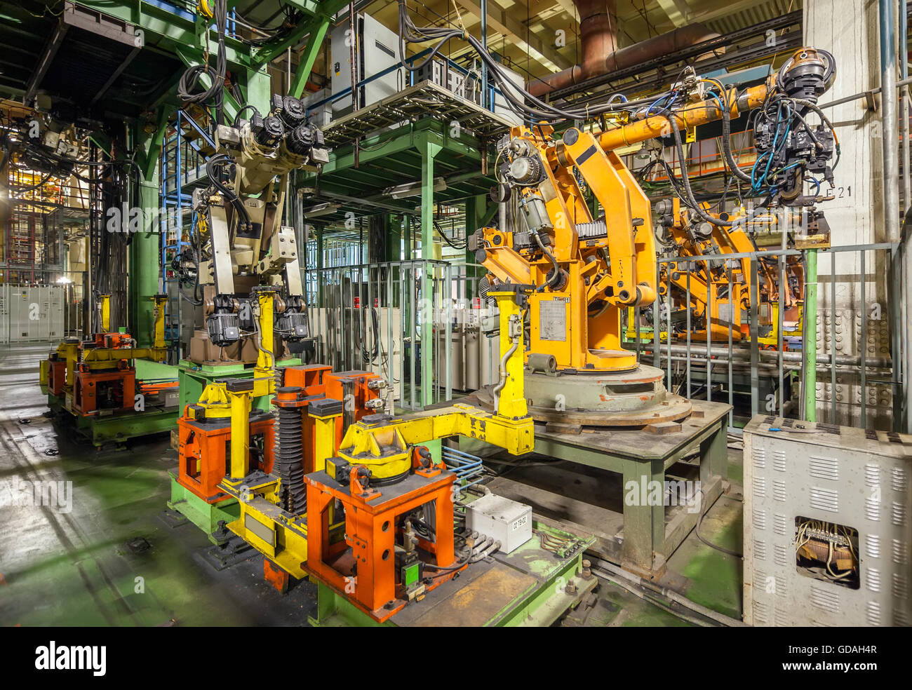 In bancarotta e abbandonato stabilimento automobilistico. Robot giallo vetture di saldatura in una linea di produzione Foto Stock