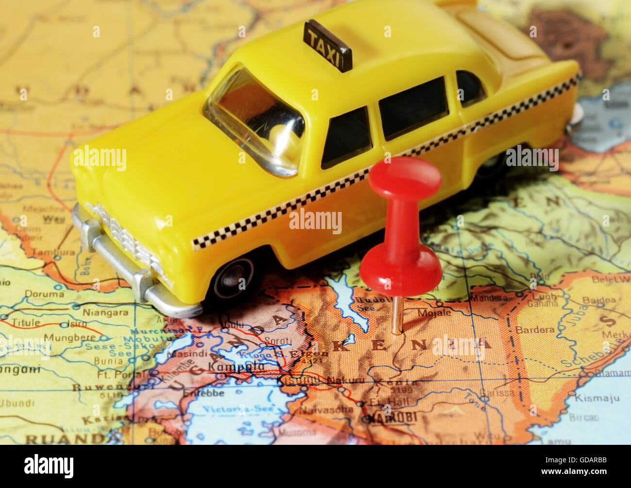 Close-up di una puntina rossa su una mappa di Kenia Africa e un taxi auto - Concetto di viaggio Foto Stock