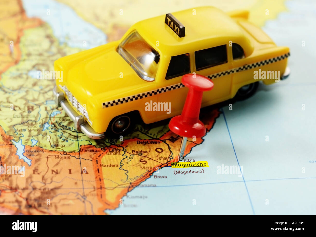 Close-up di una puntina rossa su una mappa di Mogadiscio, Somalia Africa e un taxi auto giocattolo - Concetto di viaggio Foto Stock