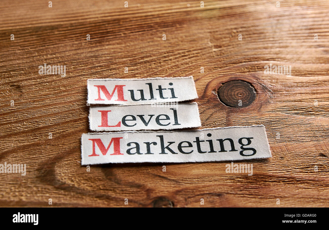 MLT- Multi Level Marketing scritto su carta e su sfondo di legno Foto Stock