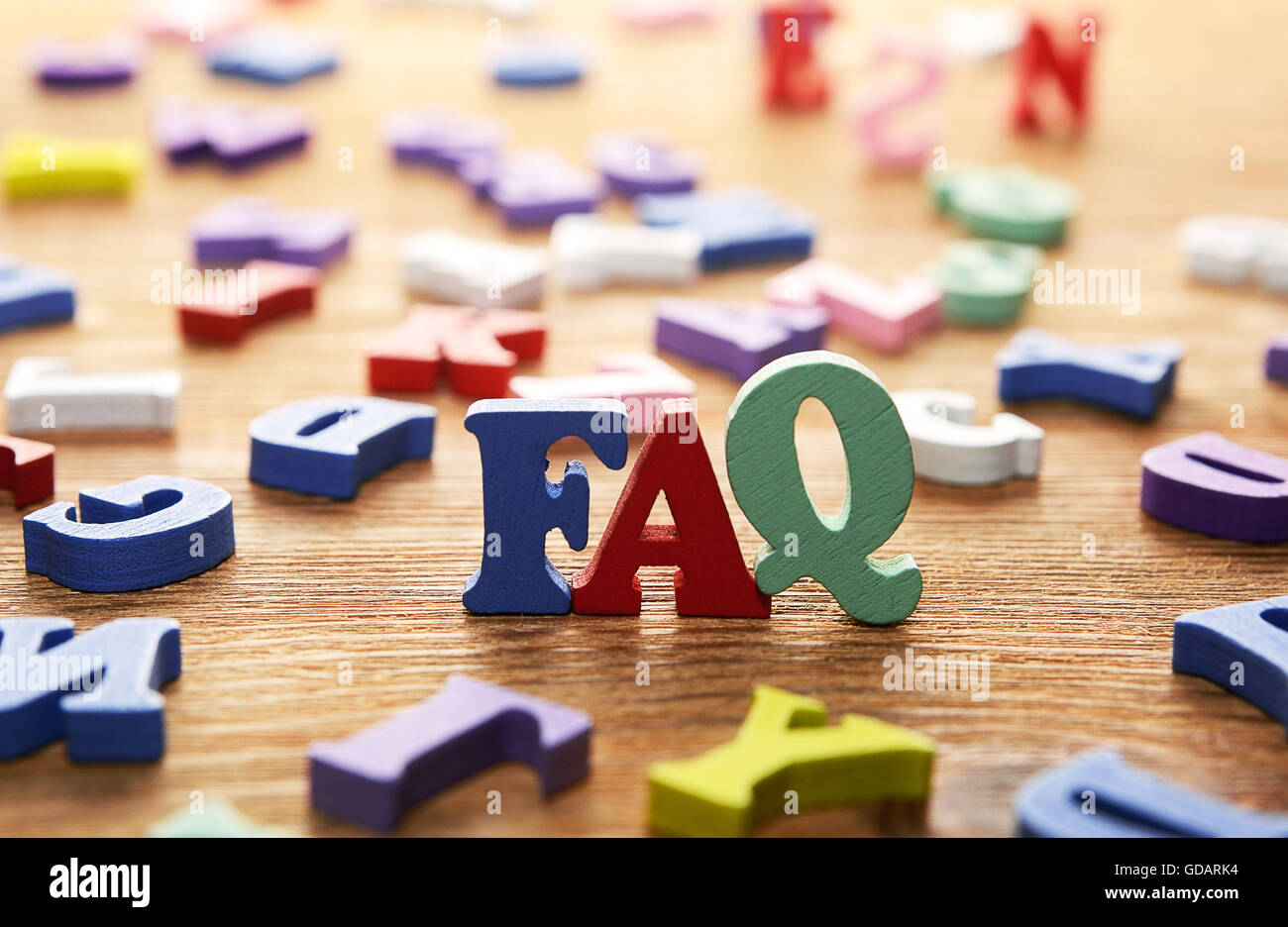 FAQ- parole realizzato da lettere multicolore su sfondo di legno Foto Stock