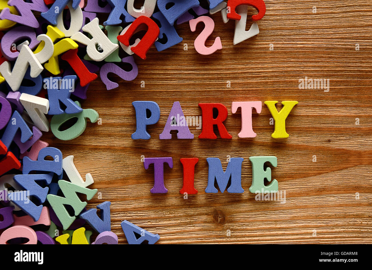 Il tempo del partito - parole realizzato da lettere multicolore su sfondo di legno Foto Stock