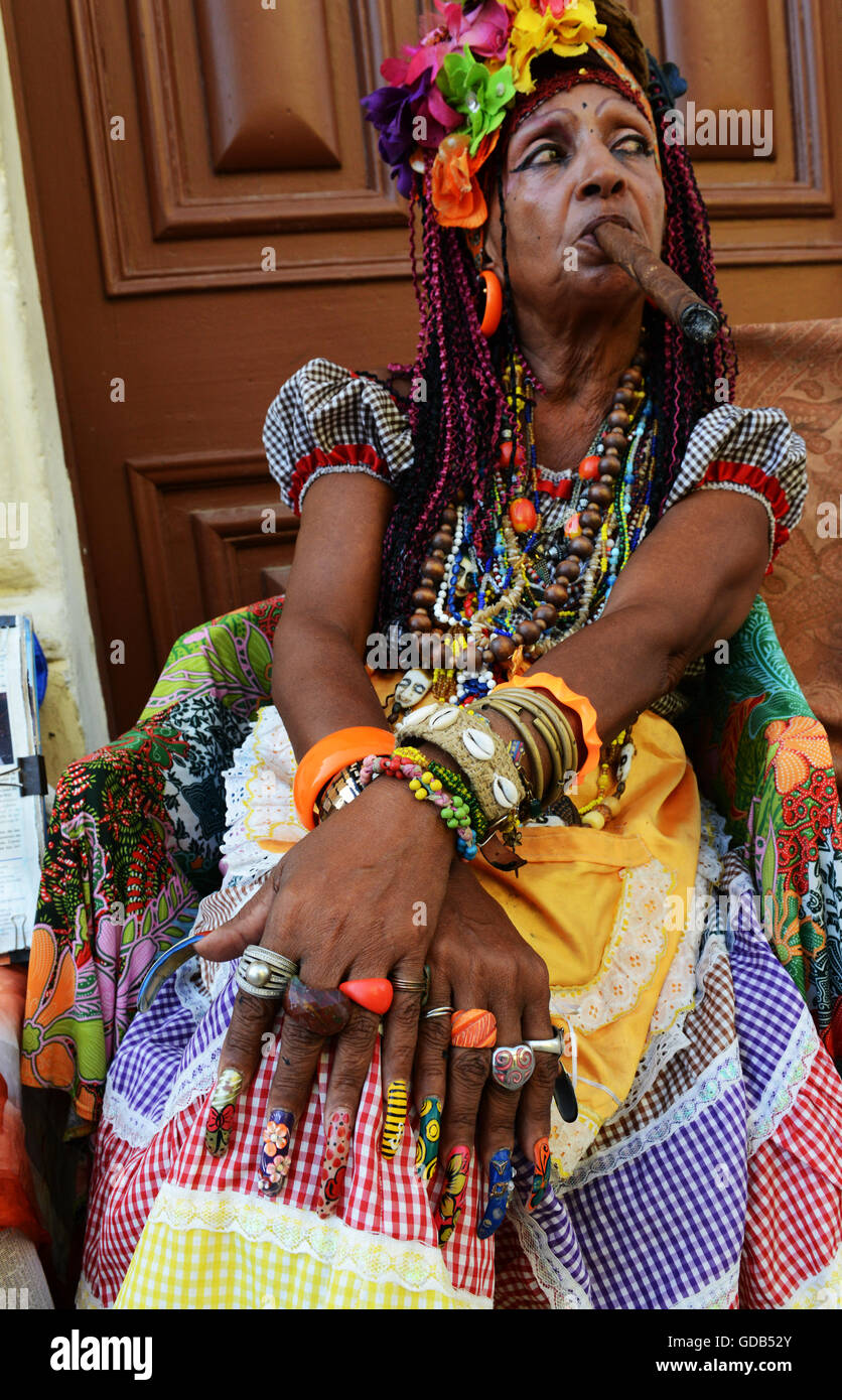 Senora Habana, una sacerdotessa di afro-cubano Santeria con colorati a lungo chiodi e un sigaro. Foto Stock