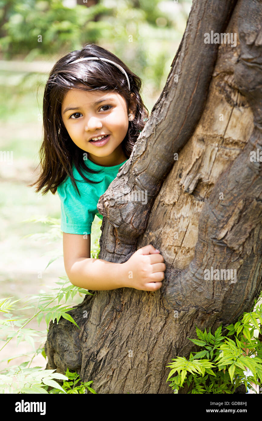 1 indian Kid girl park tronco di albero in piedi a nascondino Foto Stock