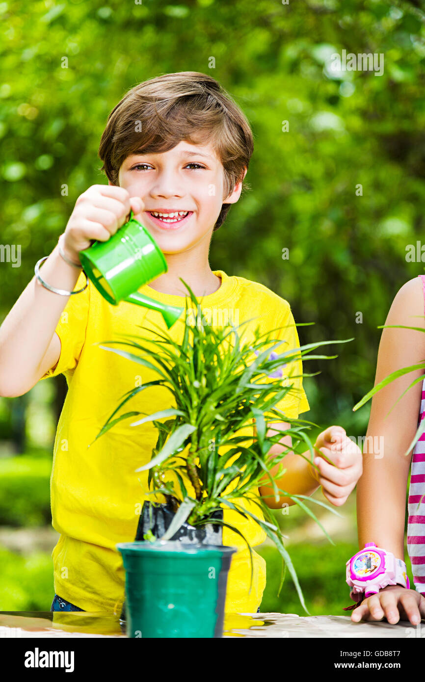 2 bambini indiani ragazzo e una ragazza amici park l'innaffiamento può versare acqua Foto Stock