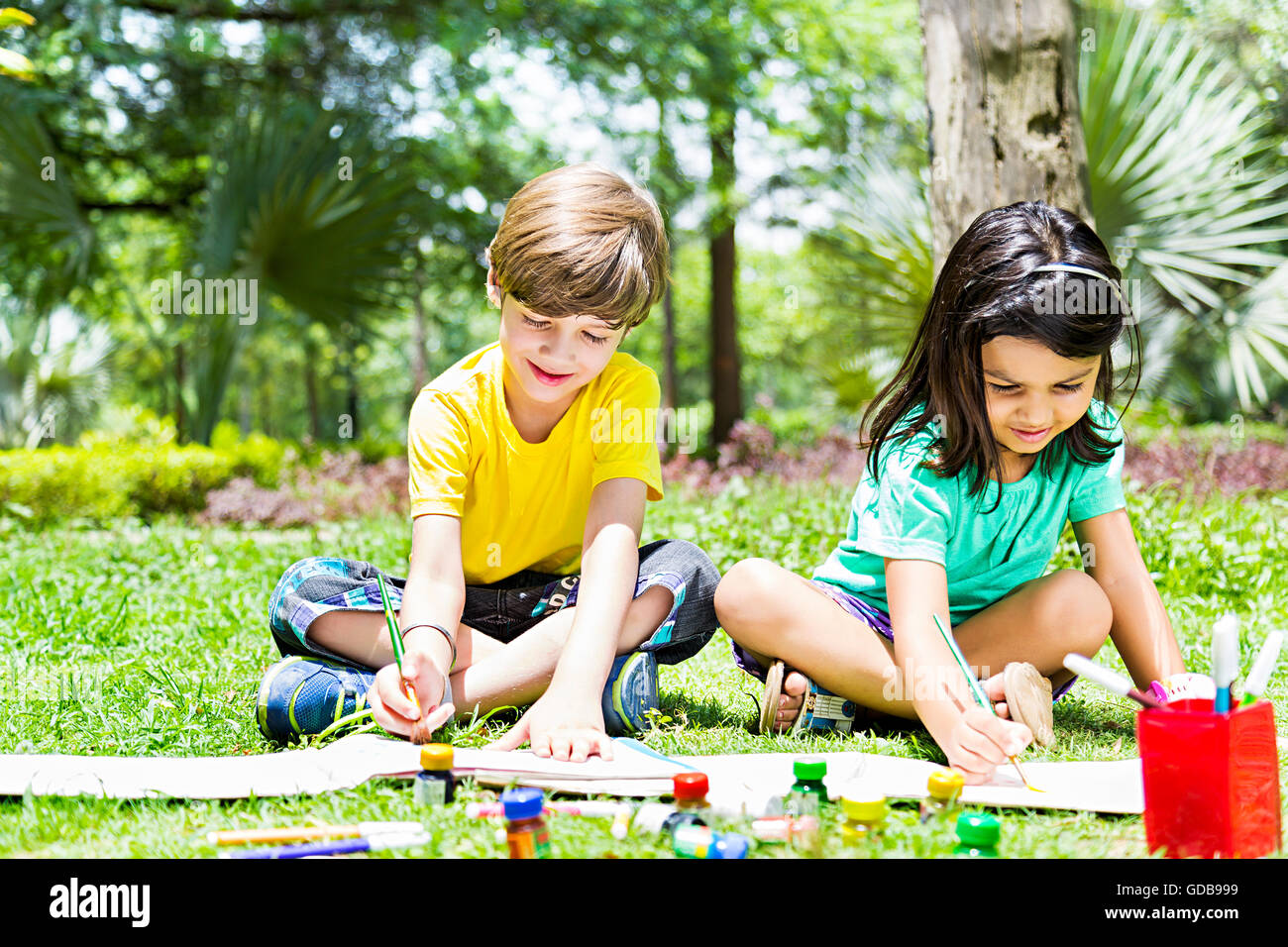 2 bambini indiani ragazzo e una ragazza amici studenti parco pittura disegno Foto Stock