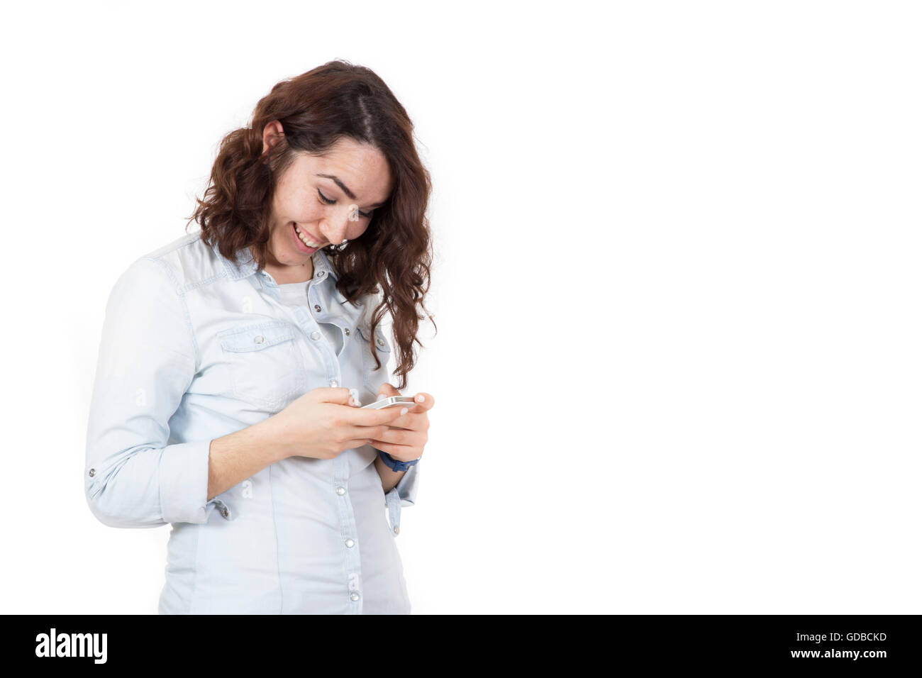 Capelli rossi felice carina ragazza giovane giocando smart phone e sorridente Foto Stock