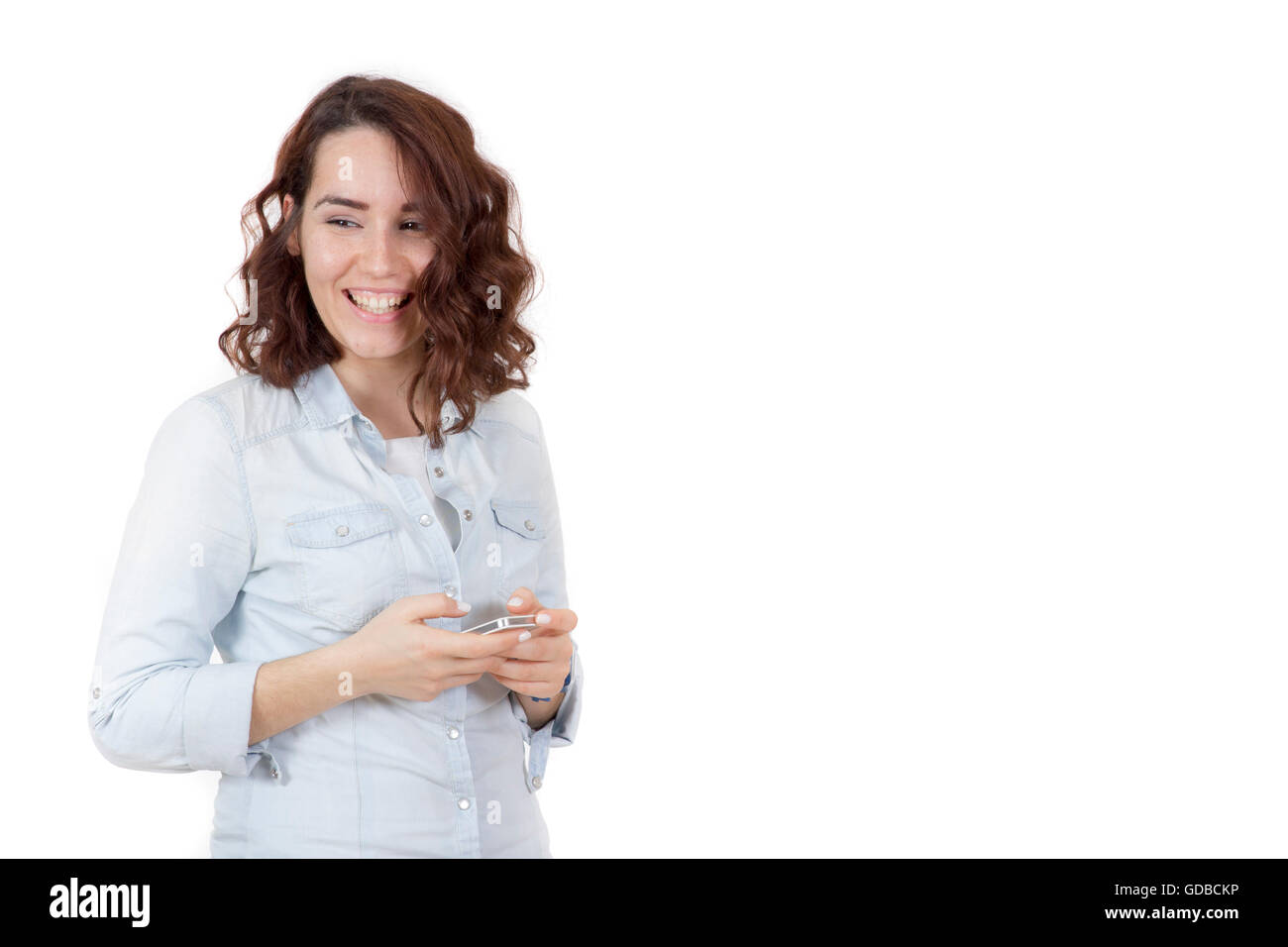 Capelli rossi felice carina ragazza giovane giocando smart phone e sorridente Foto Stock