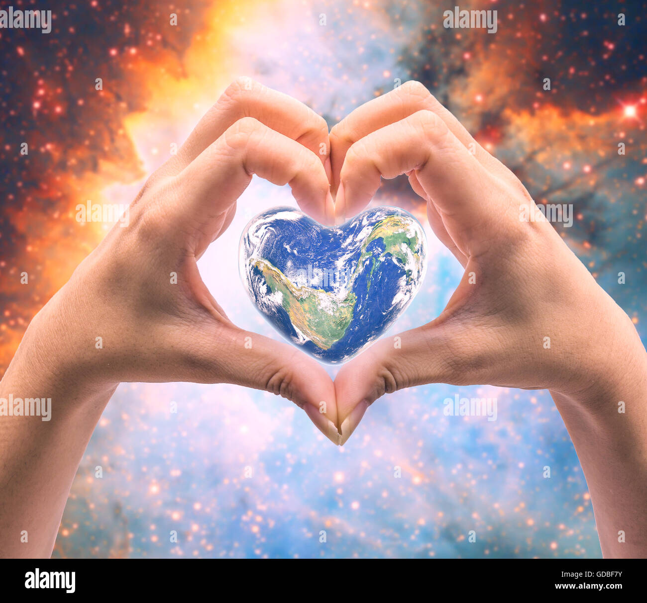 Mondo in forma di cuore con sopra le donne le mani umane su sfocato sfondo naturale: Mondo Salute del cuore giorno,Elemento di questa immagine fur Foto Stock