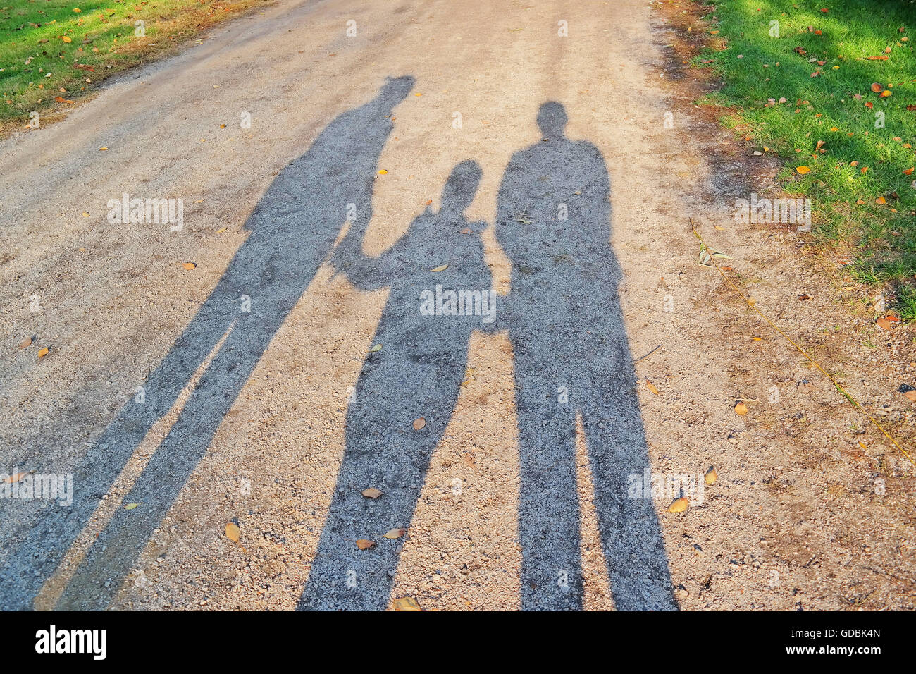 Ombra di una famiglia a piedi in autunno sunshine. Foto Stock