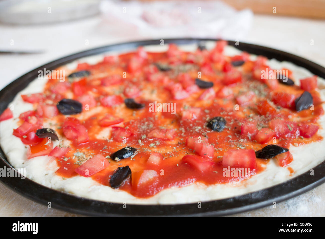 Materie pizza con salsa di pomodoro e olive nere Foto Stock