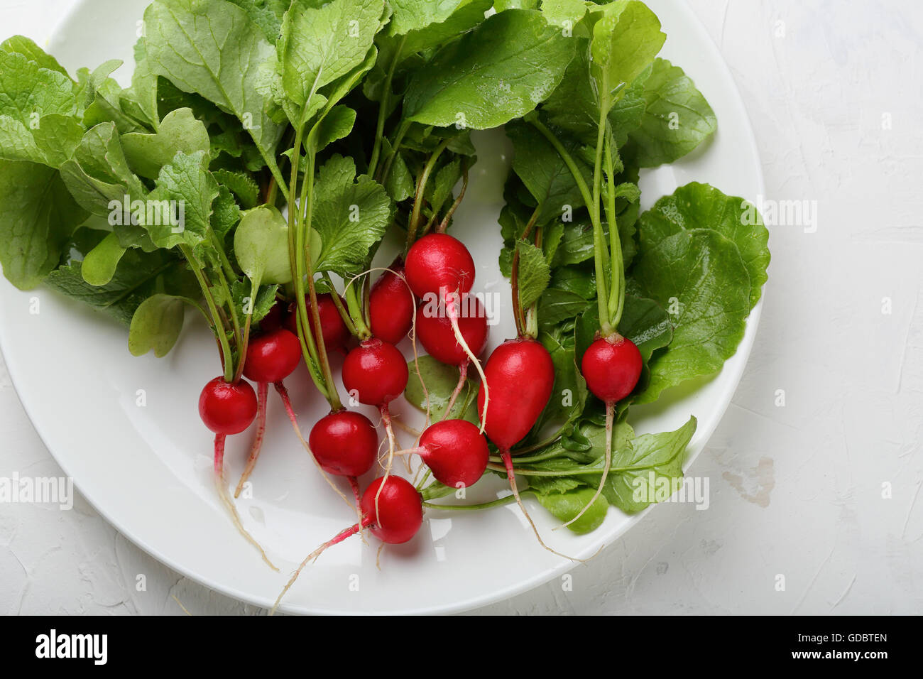 Rafano organico sulla piastra bianca, verdure fresche Foto Stock