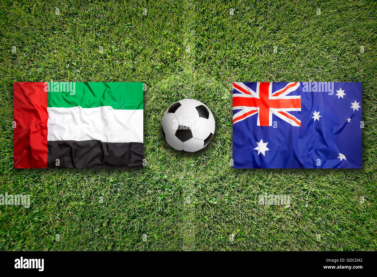 Emirati Arabi Uniti vs. Australia bandiere sul verde del campo di calcio Foto Stock