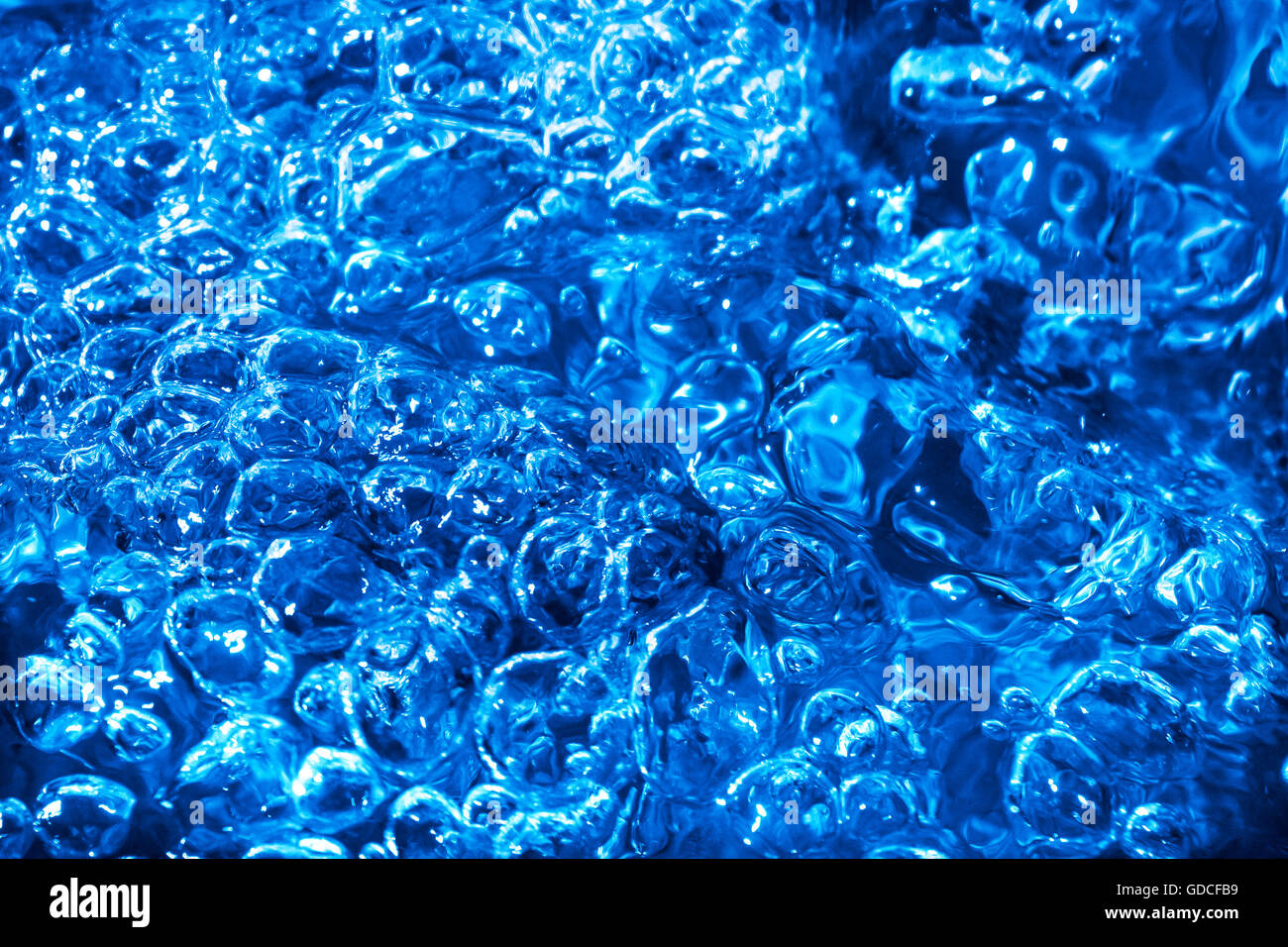 Blue splash e increspature sul flusso d'acqua. Splash acqua texture di superficie. Acqua blu sullo sfondo Foto Stock