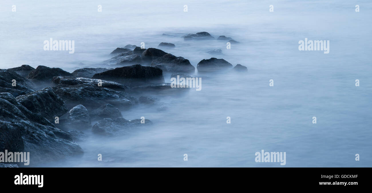 Croce tranquillo paesaggio elaborato immagine del mare calmo sulle rocce di sunrise Foto Stock