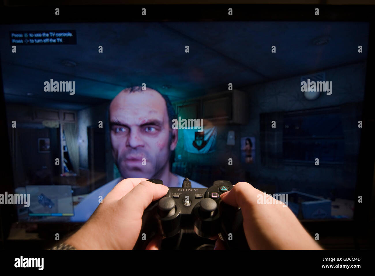 Due mani tenendo una Sony Playstation Controller davanti a uno schermo TV  con Trevor dal Grand Theft Auto V video gioco Foto stock - Alamy