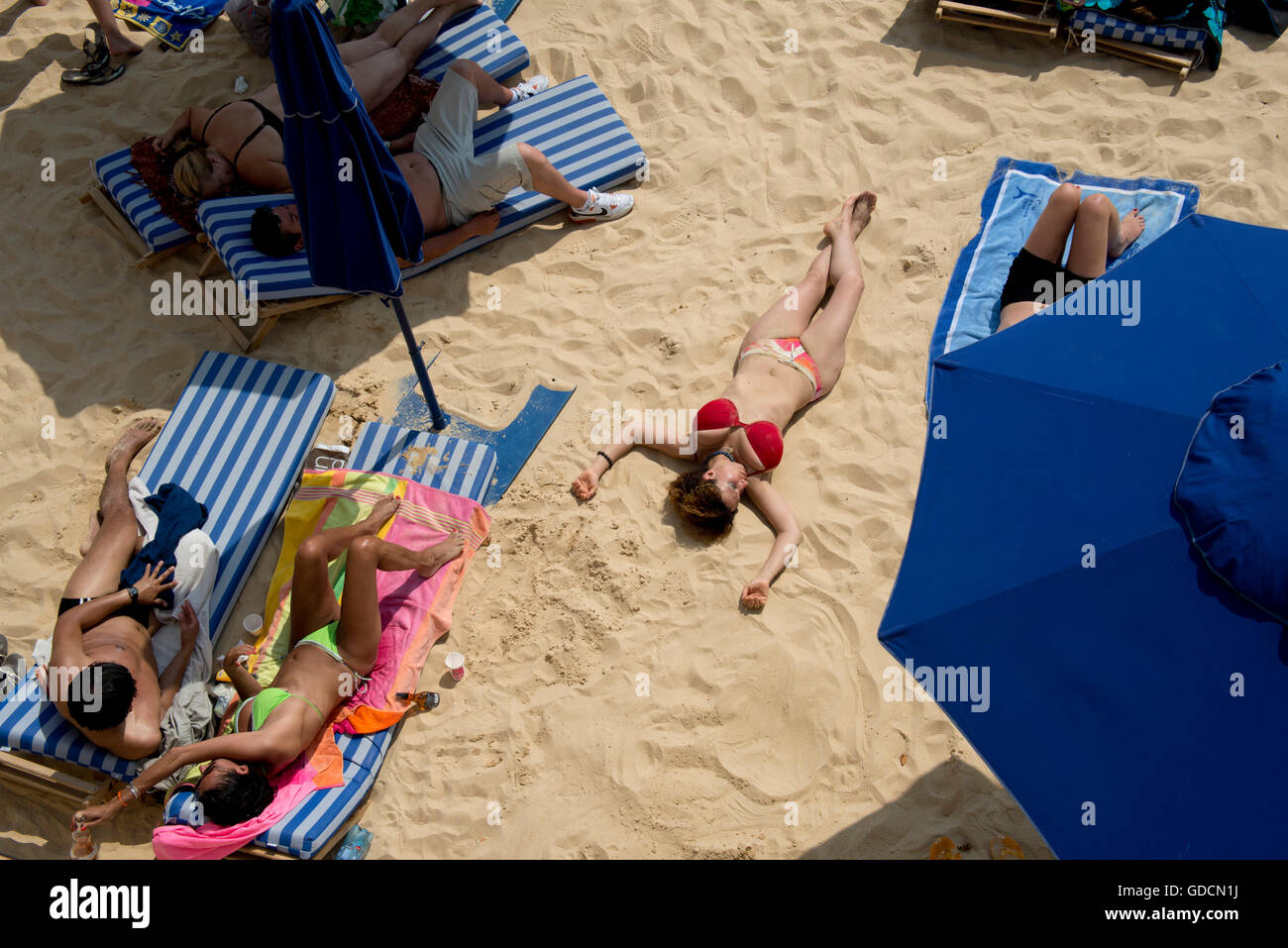 Signora in spiaggia a prendere il sole Foto Stock