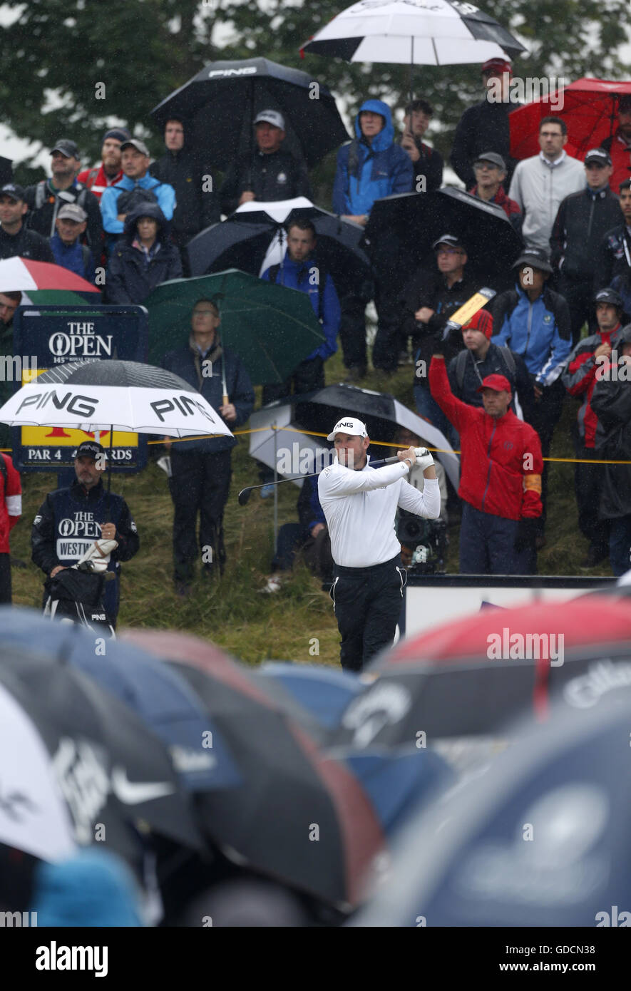 L'Inghilterra del Lee Westwood tees off tra un mare di ombrelli da pioggia cade durante la seconda giornata del Campionato Open 2016 al Royal Troon Golf Club, South Ayrshire. Foto Stock