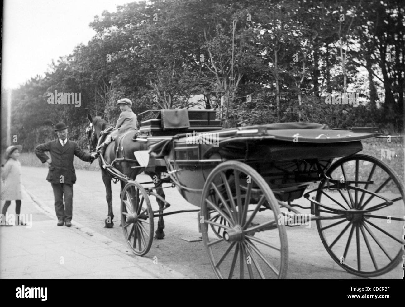 Il ragazzo si siede sul cavallo con carro c1910. Fotografia di Tony Henshaw Foto Stock