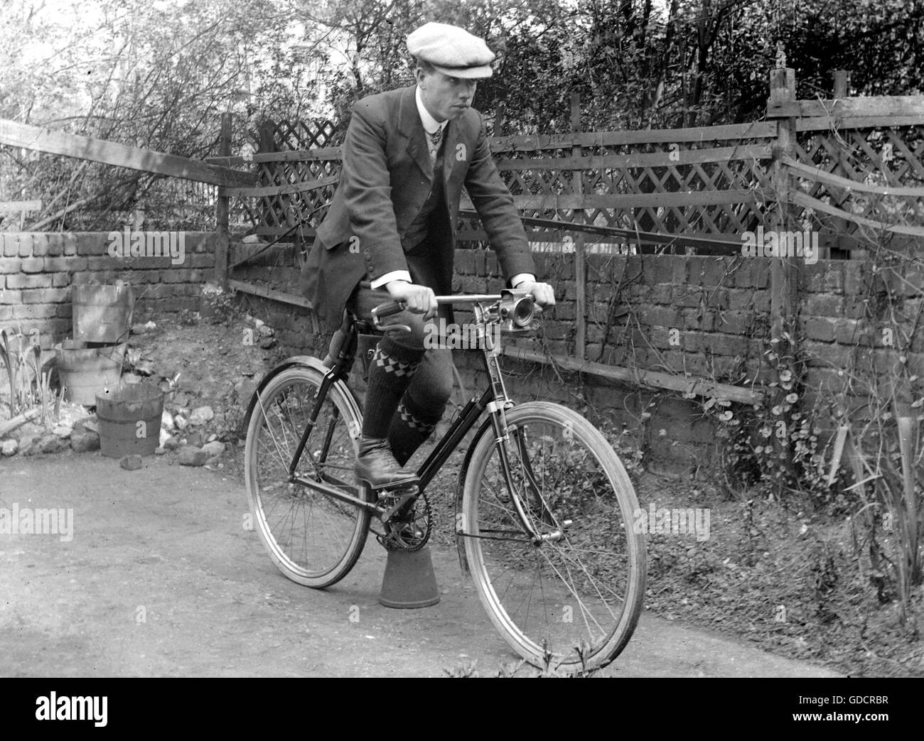 L uomo nel tappo piatto sulla bicicletta c1920. Fotografia di Tony Henshaw Foto Stock