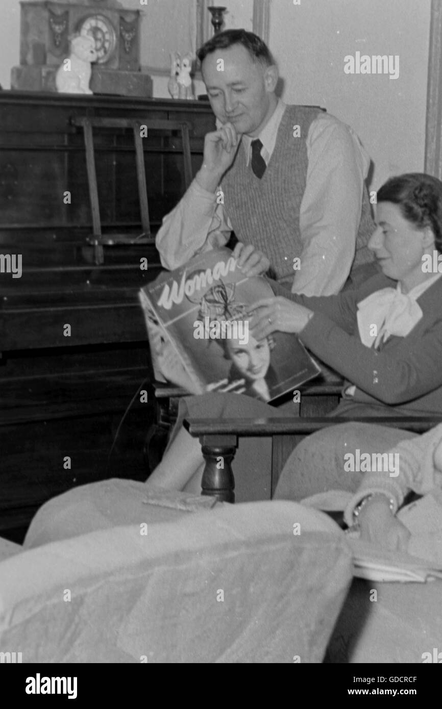 Famiglia soggiorno scena, nota la copia della rivista Donna, storia sociale, Inghilterra c1960. Fotografia di Tony Henshaw Foto Stock